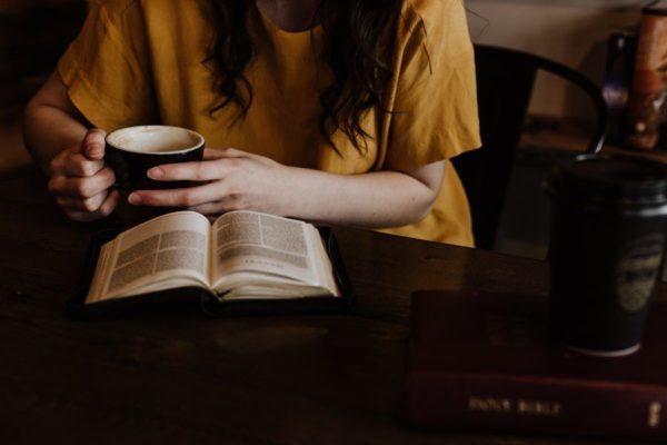 コーヒーを飲みながら本を読む女性